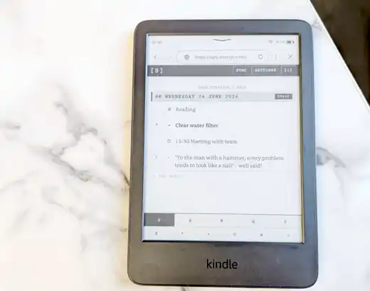 ShortJo running on a Kindle e-ink reader photographed on a light marble tabletop